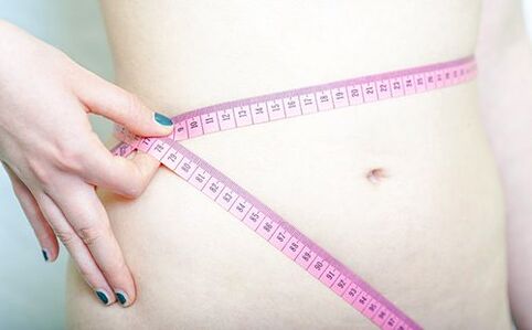 Seorang gadis mengukur pinggangnya untuk merekodkan keputusan mengikuti diet Dukan